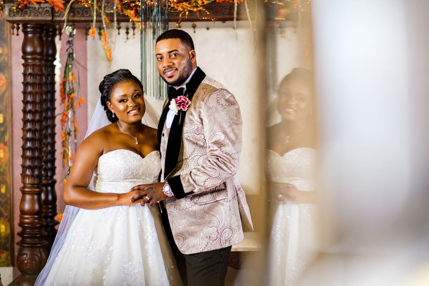 A couple shares an intimate moment during their wedding reception in an ornate venue.