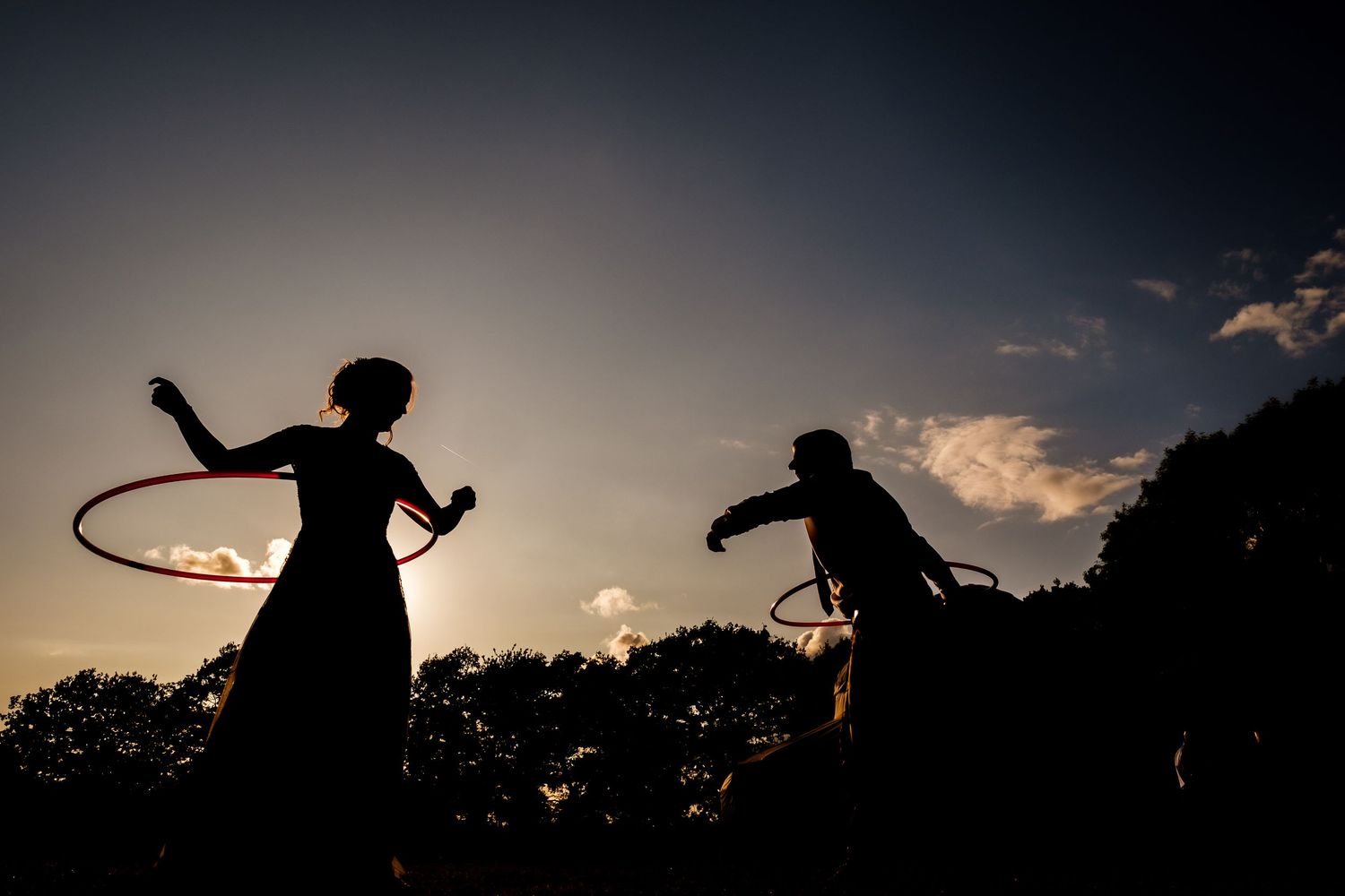 Silhouettes of playful children against a dramatic sunset sky.