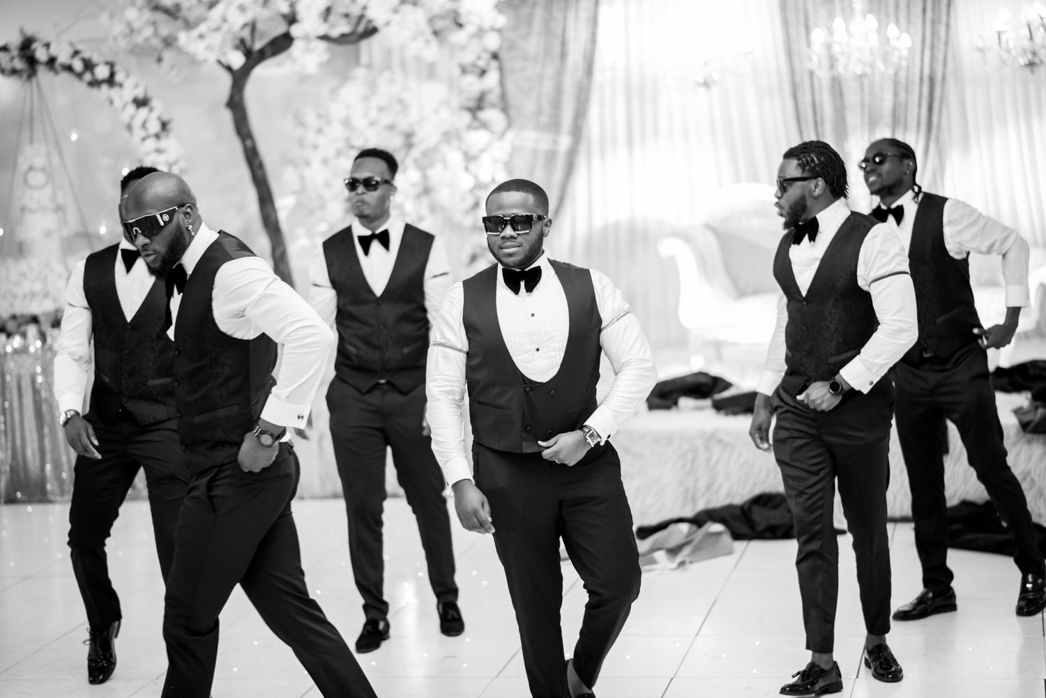 Black and white photos of groomsmen striking fun poses in formal attire.