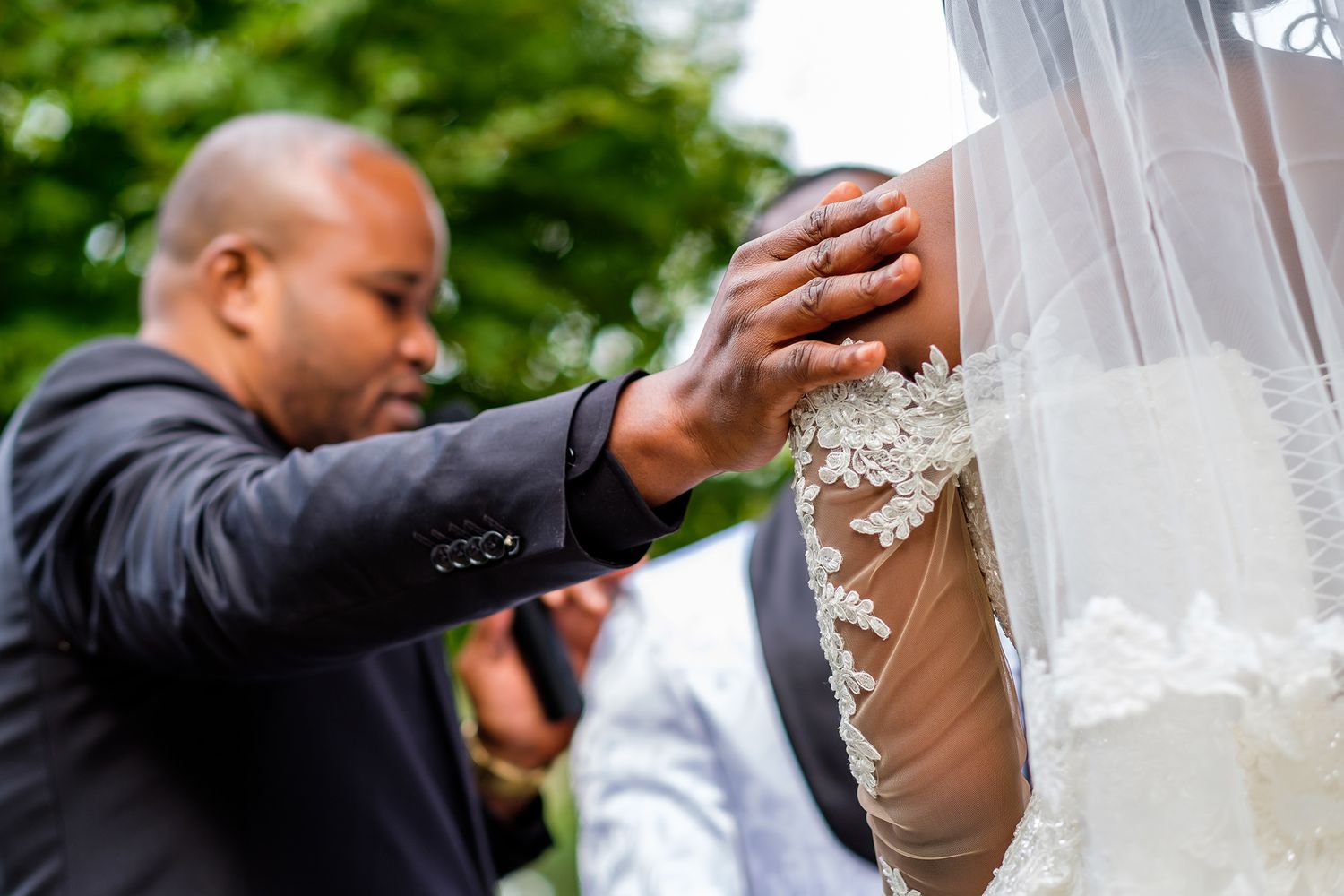 White bridal veil flowing in gentle breeze during outdoor ceremony.
