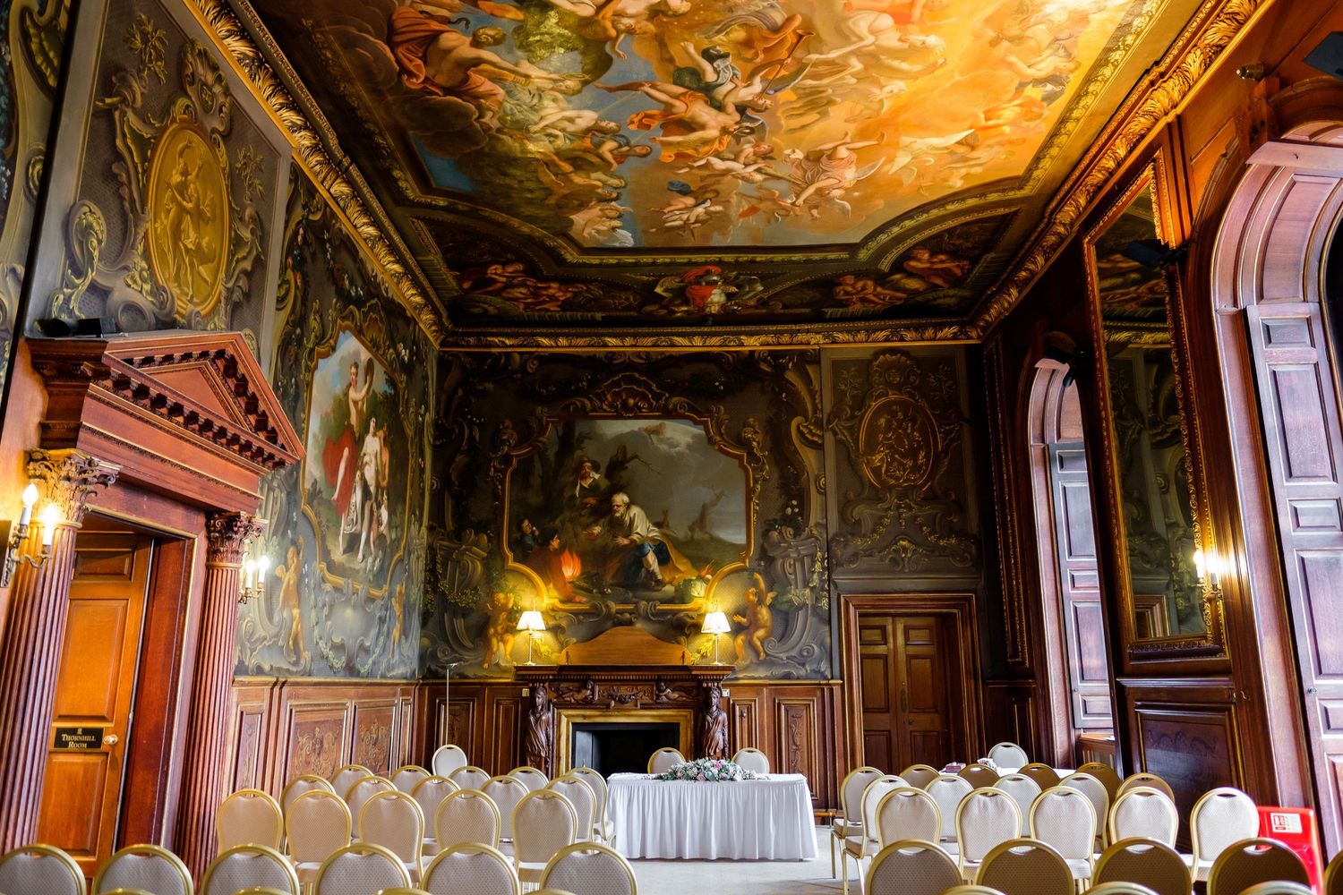 Ornate baroque ceiling with detailed frescoes in a grand wedding venue.