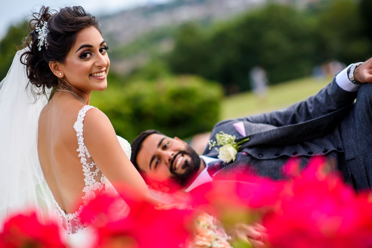 Vibrant wedding photos with bright pink flowers in the foreground.
