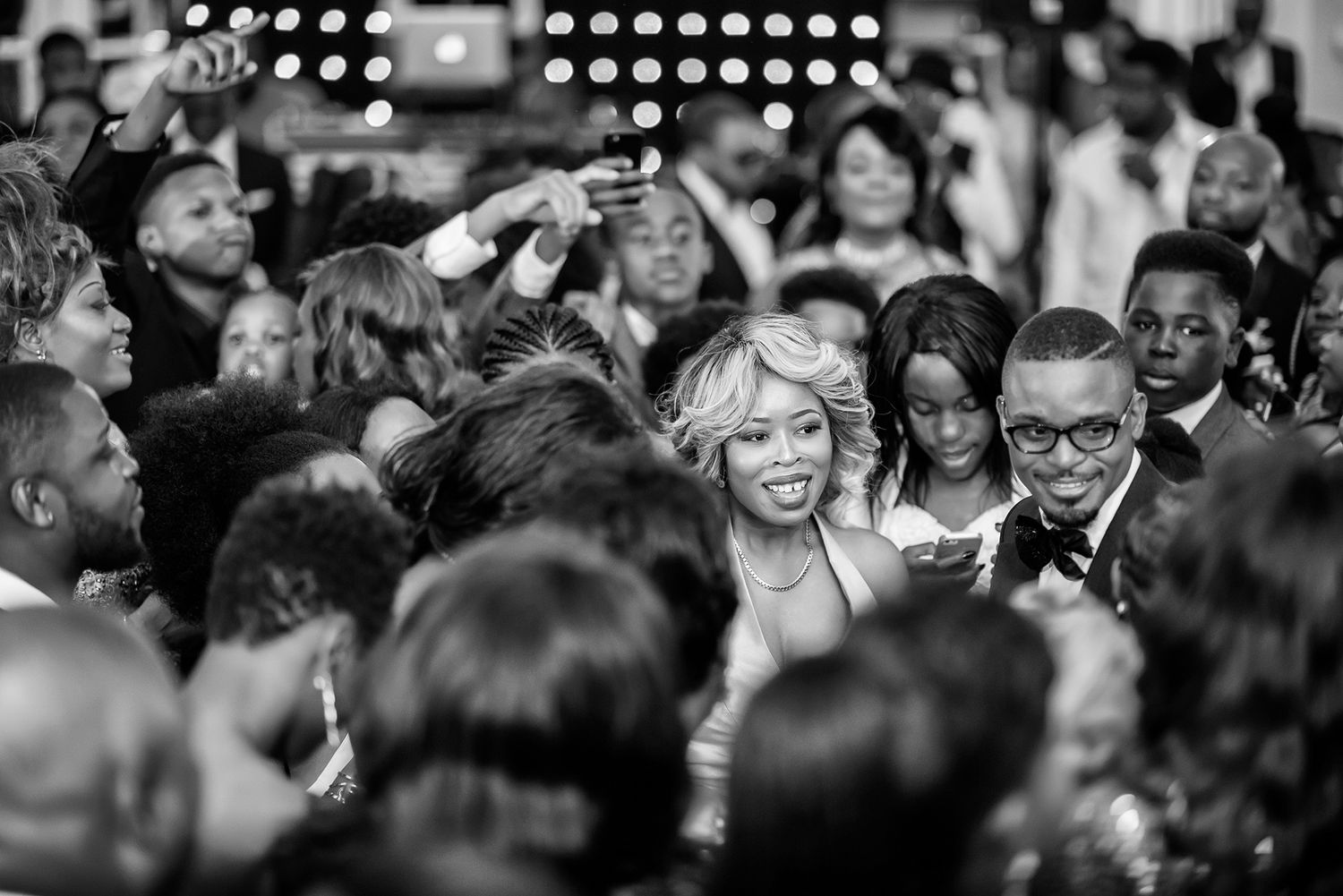 Black and white candid shots of wedding guests enjoying the reception celebration.