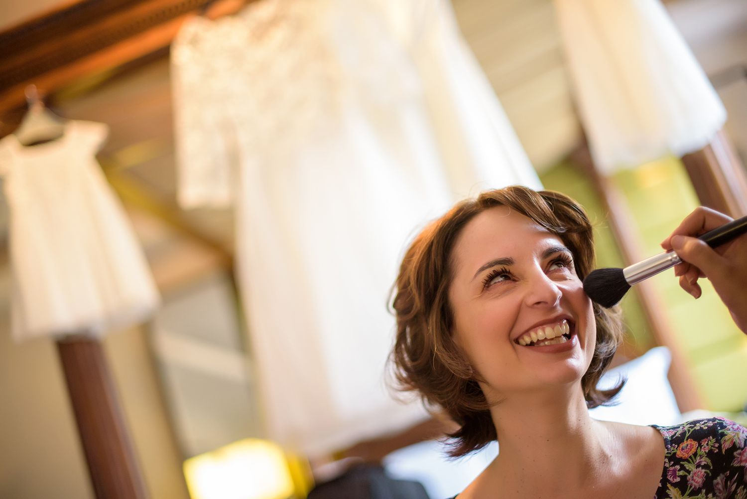 Candid getting ready moments captured during wedding day preparations with professional makeup application.
