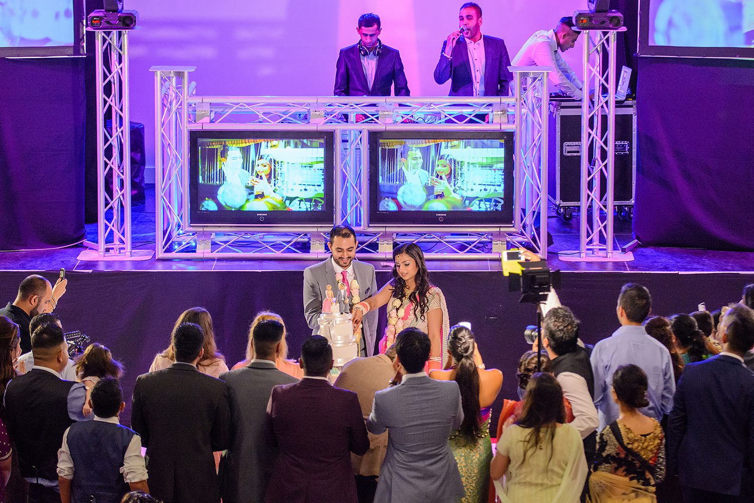 Event venue with large screens and stage lighting setup for a formal presentation.