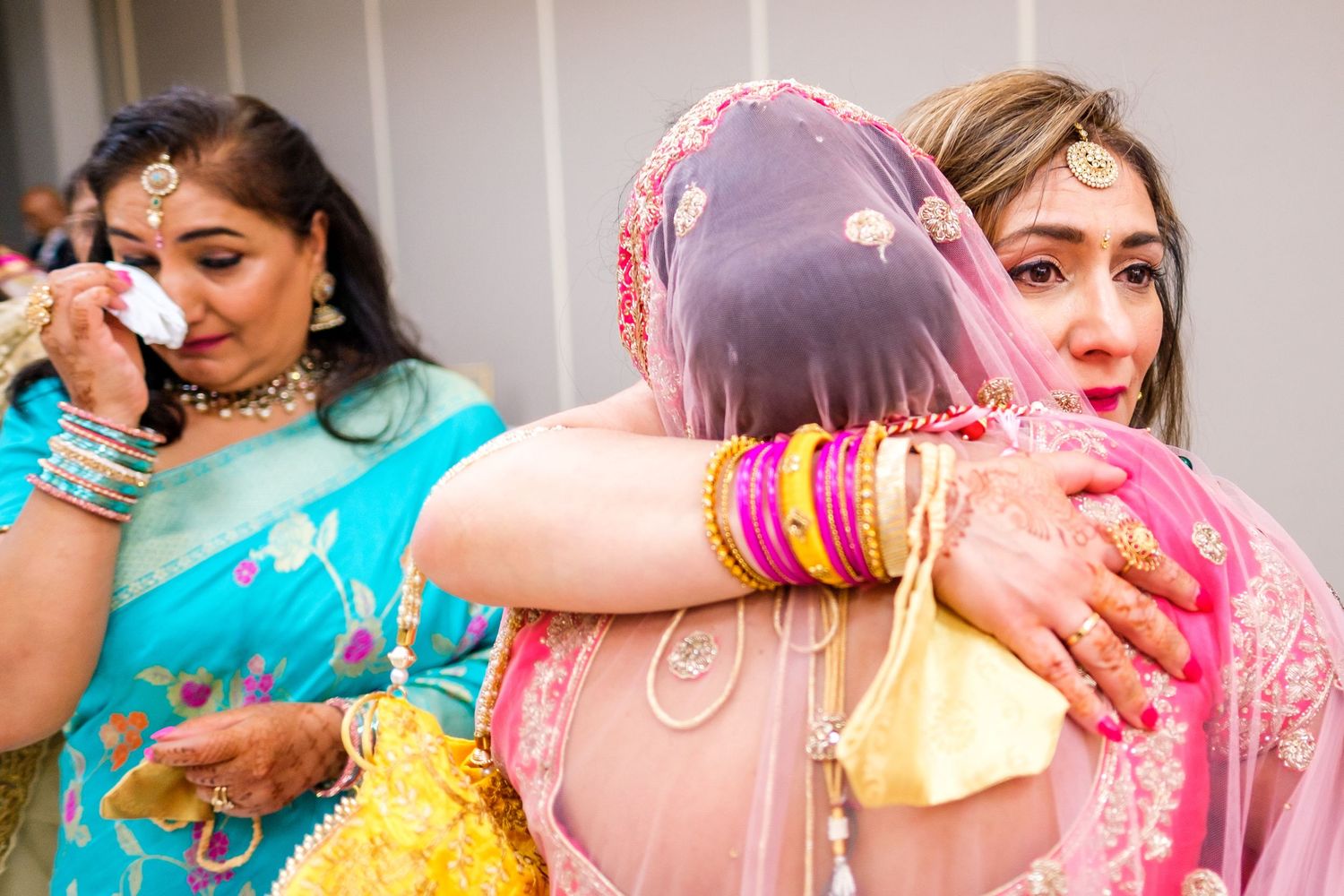 Wedding celebration featuring vibrant traditional Indian attire in turquoise and pink colors.