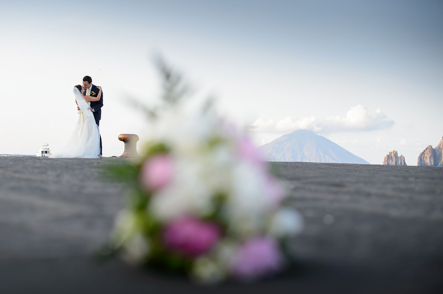 Artistic silhouette shot of wedding couple against mountain backdrop.