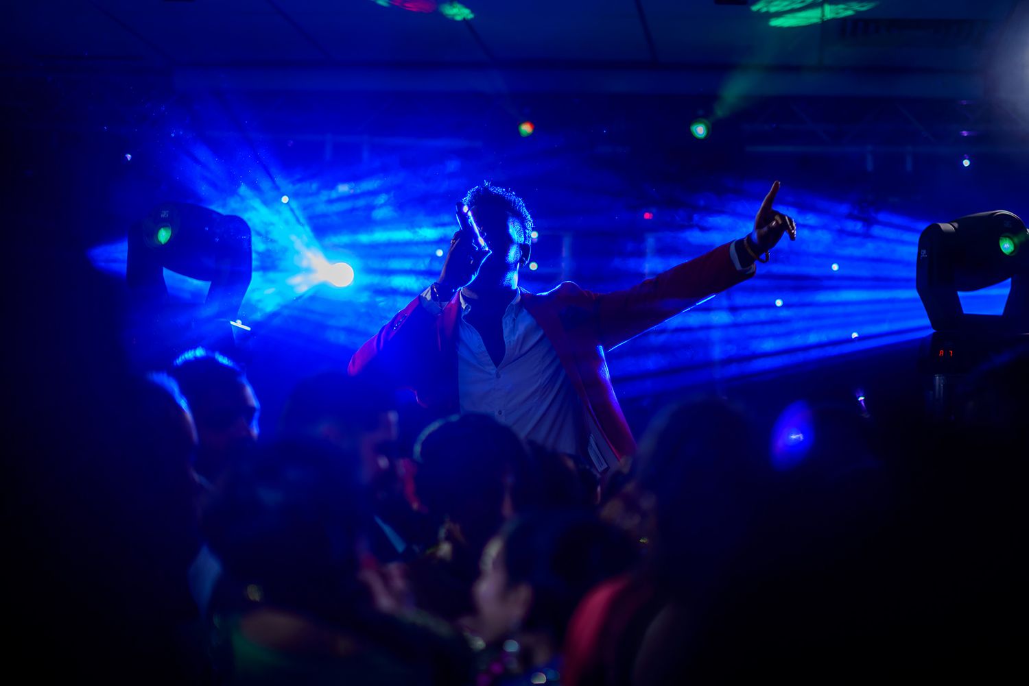 Dance floor illuminated with blue and green lights during evening wedding celebration.