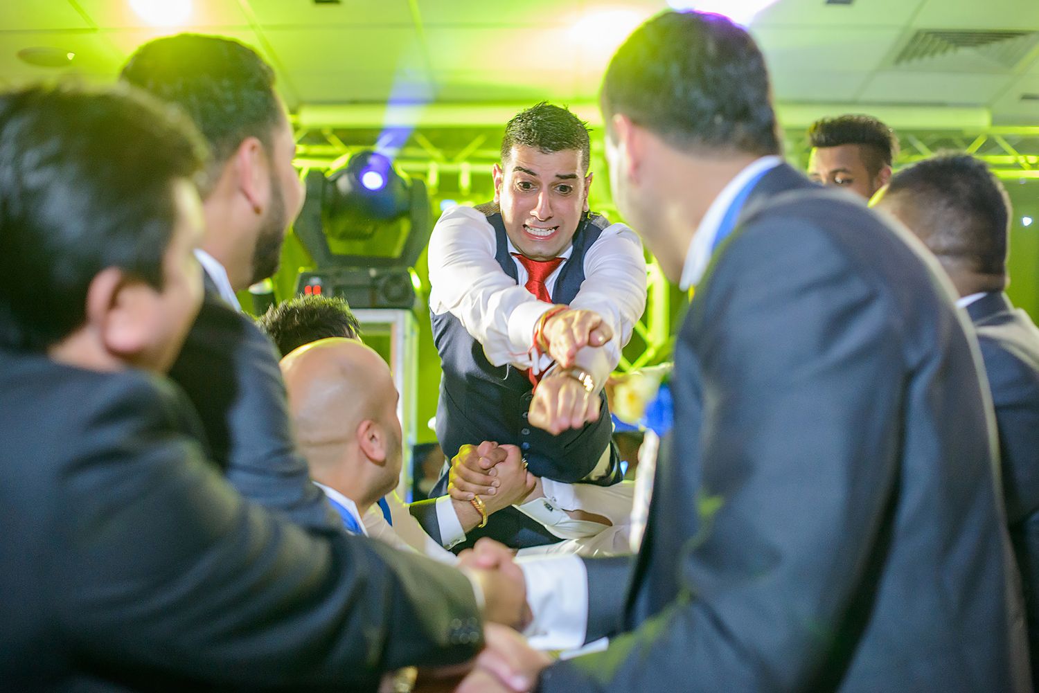 Wedding guests mingling and socializing at tables during a reception.