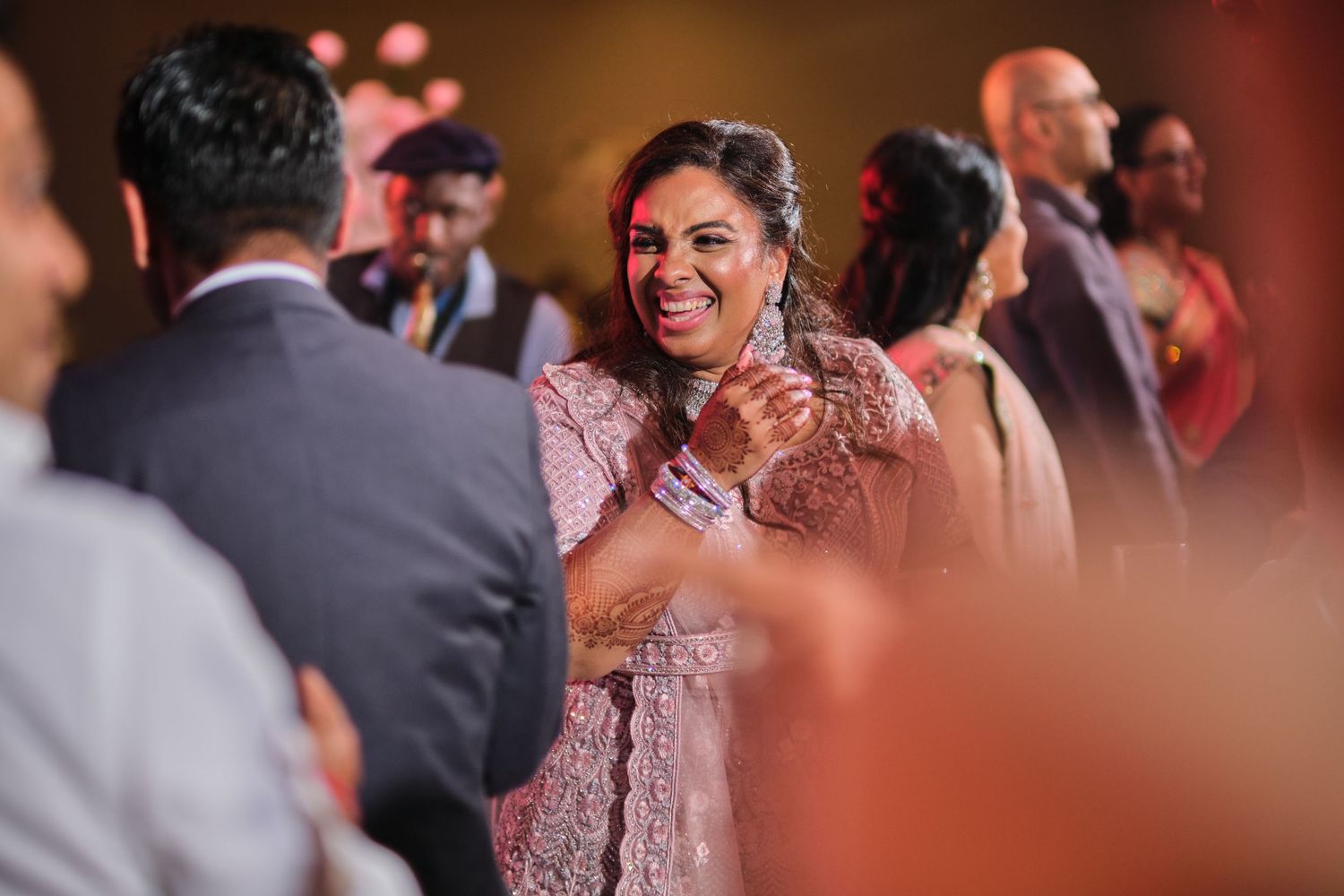 Wedding celebration with guests dancing and enjoying festivities in formal attire.