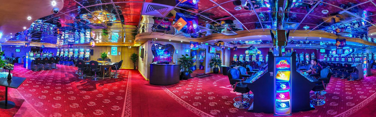 Panoramic view of nightclub interior with colorful LED lighting and bar setup.