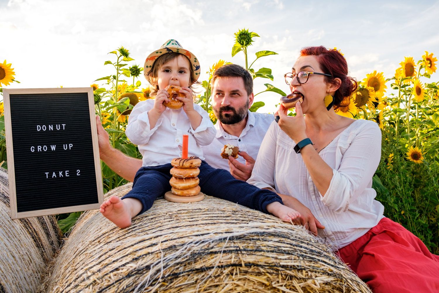 Family sharing laughter and fun moments together in a sunflower field during golden hour.
