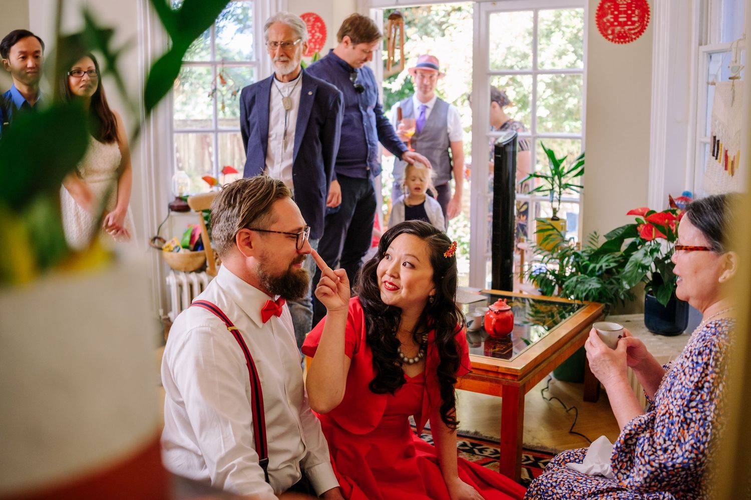 People gather around a table for a festive holiday celebration with decorations and drinks.
