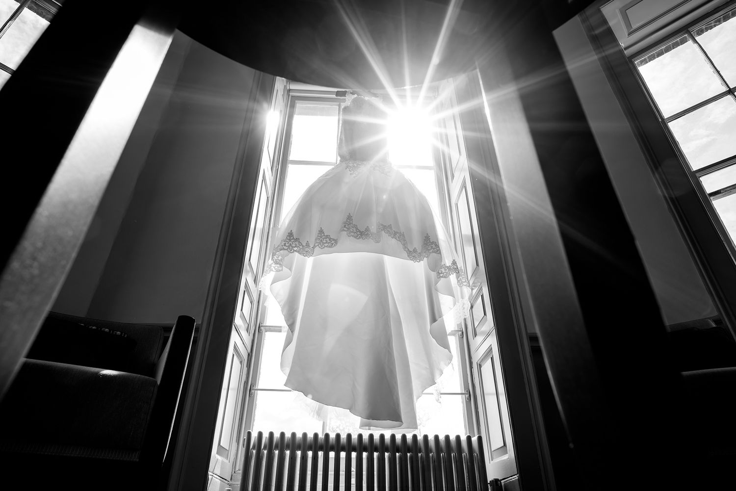 Dramatic black and white architectural shot showing sunlight streaming through tall windows.