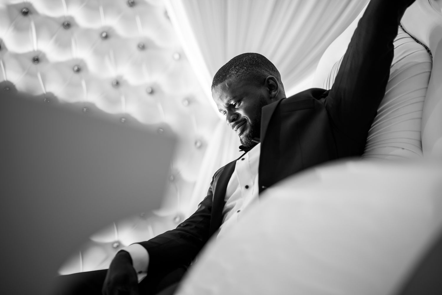 Black and white photo of a guest raising their arms in celebration at a wedding reception.