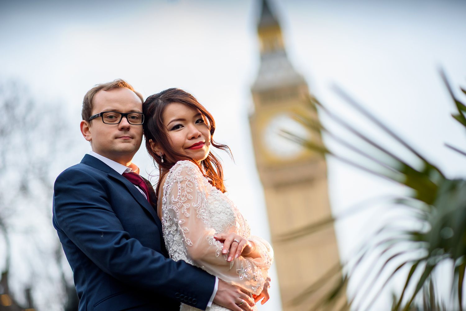 A romantic wedding photo shoot near a historic cathedral featuring a bride in lace and groom in navy.