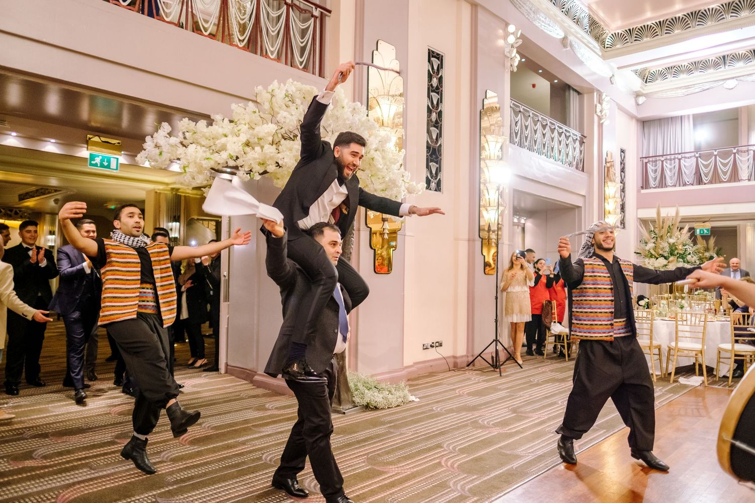 A sequence of dance moves being performed in a bright indoor hallway or shopping center.