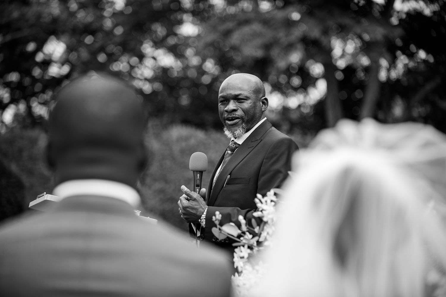 Black and white photo capturing emotional reactions during an outdoor wedding ceremony.