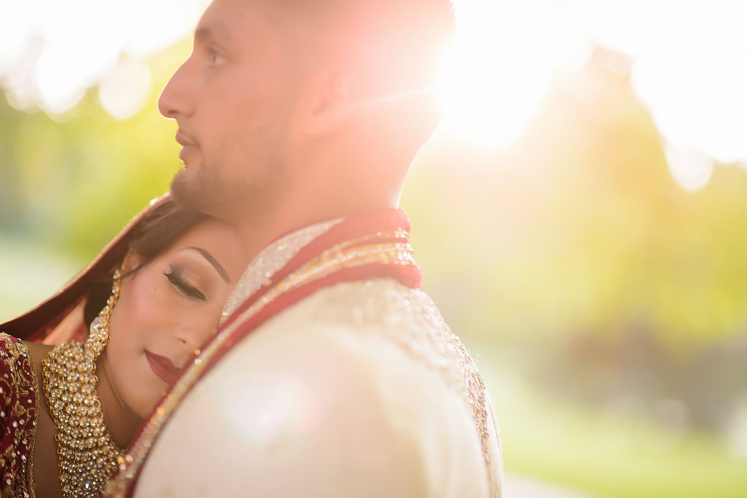 Romantic sunset portrait of couple in traditional South Asian wedding attire.
