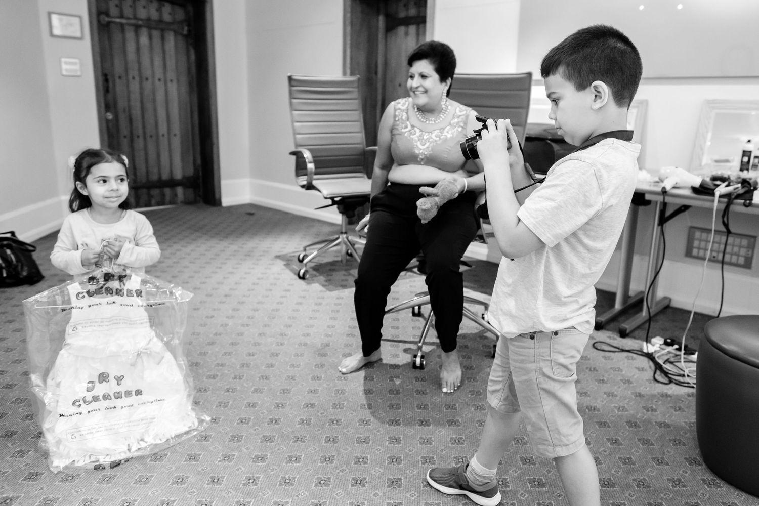 Black and white photo of children playing and dancing in a carpeted room.