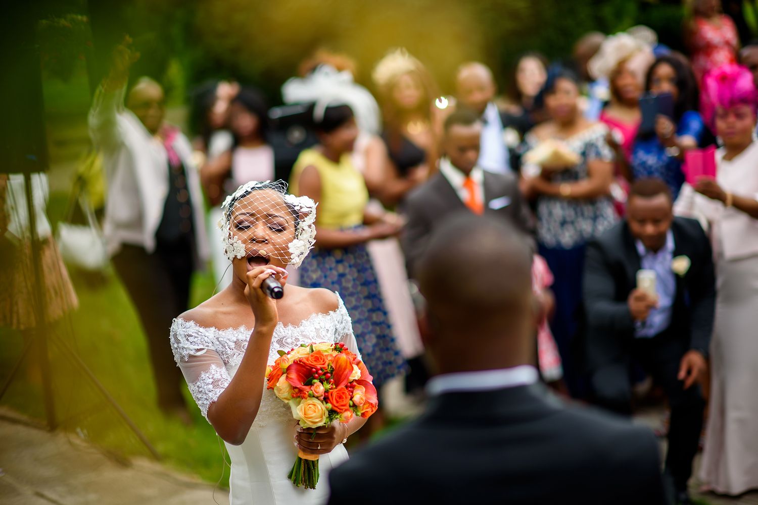 Outdoor wedding celebration with guests gathered in a garden setting.