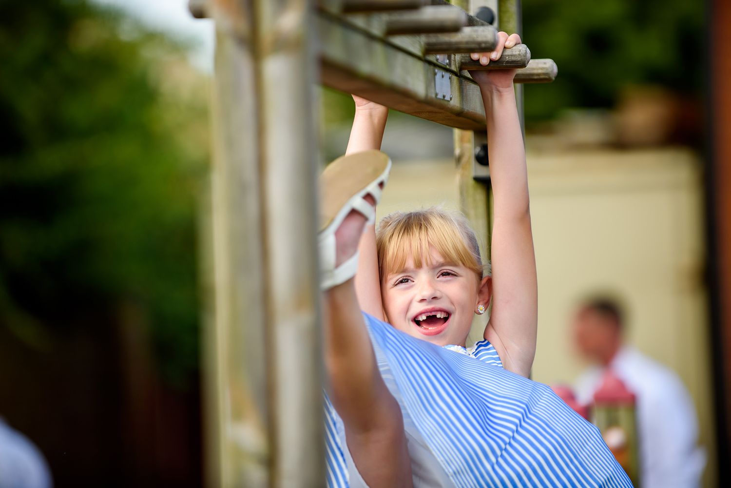 Young child playing and jumping outdoors during wedding celebration.