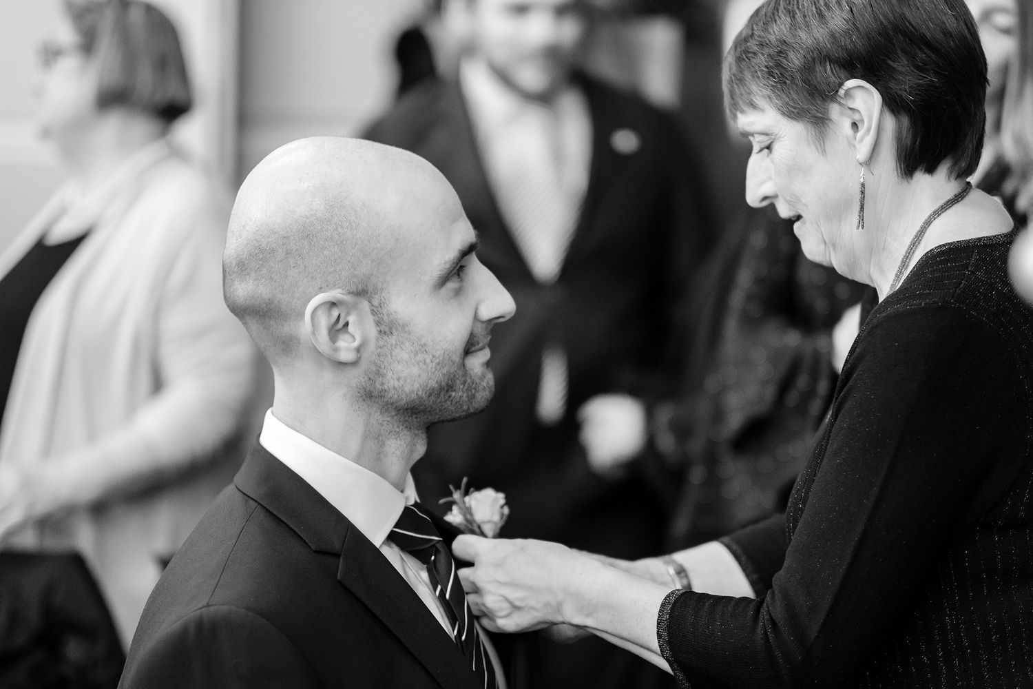 Black and white candid shots of people interacting at formal gathering.