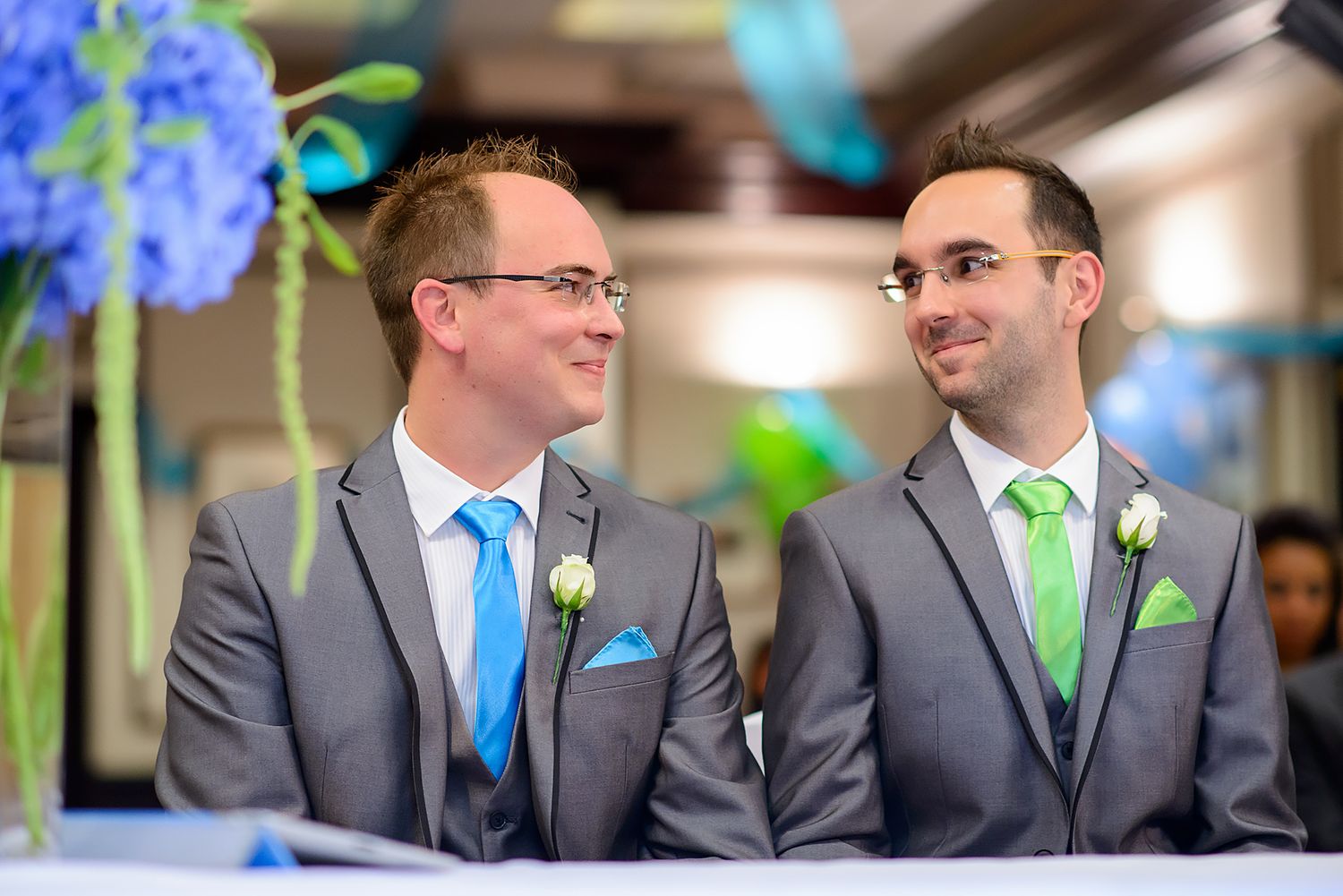 Wedding party members in grey suits with bright green and blue accent accessories.