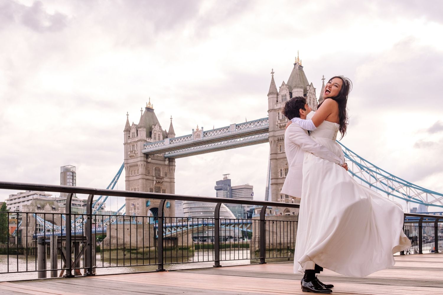 Newlyweds pose for romantic photos along Tower Bridge in London.
