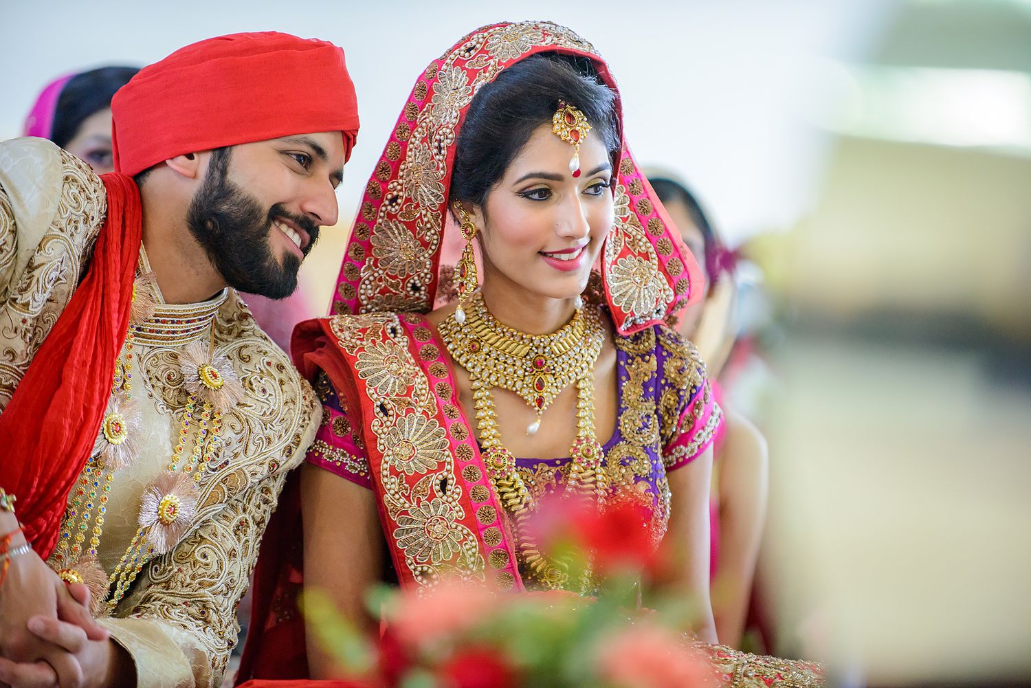 Traditional Indian wedding ceremony with detailed bridal attire in red and gold colors.