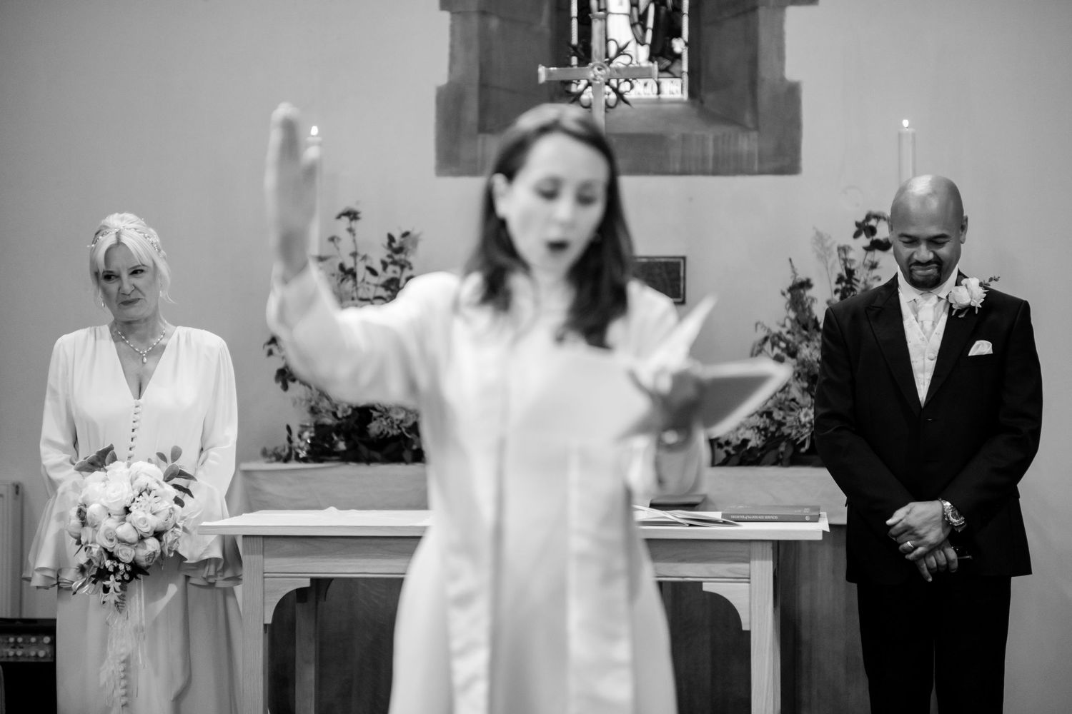 A series of candid black and white wedding photos showing emotional moments during the ceremony and reception.