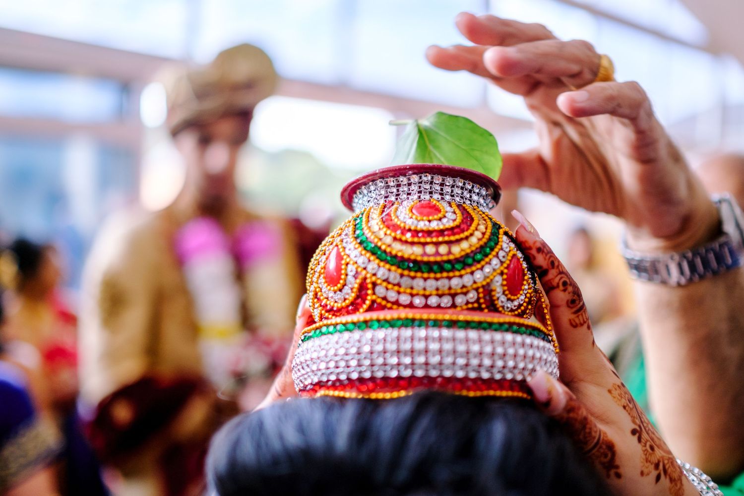 Decorative traditional Indian wedding headpiece with colorful beads and ornate details against a blurred background.