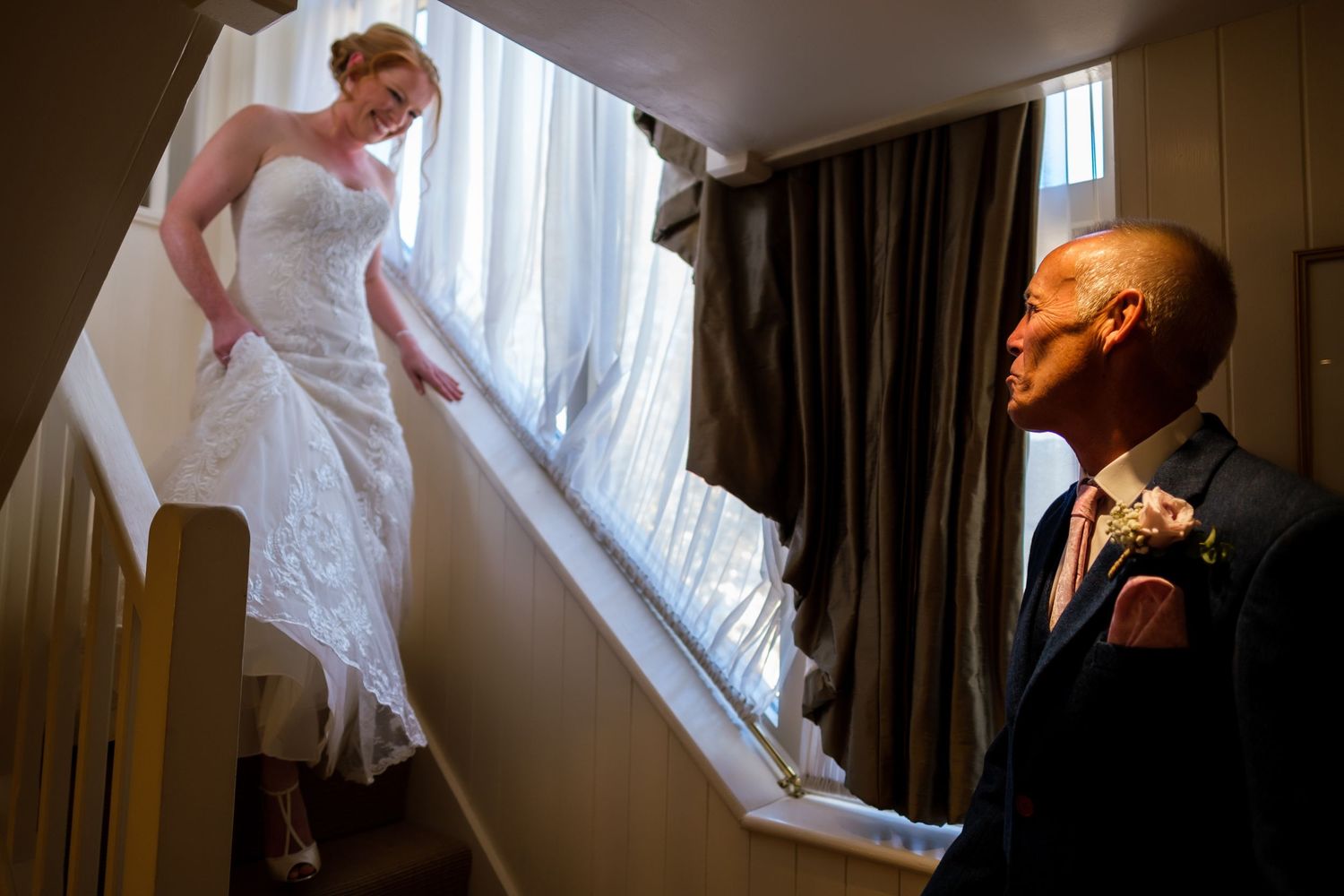 Light streams through windows creating dramatic silhouettes during wedding preparations.
