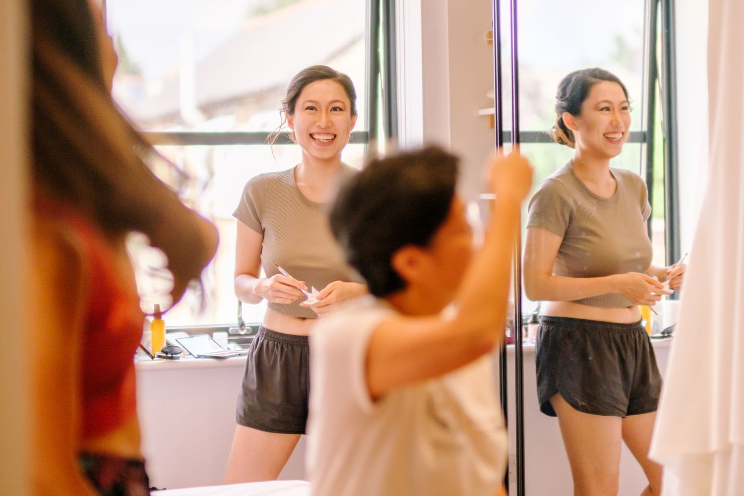 Students practicing ballet moves together in a bright dance studio with large windows.