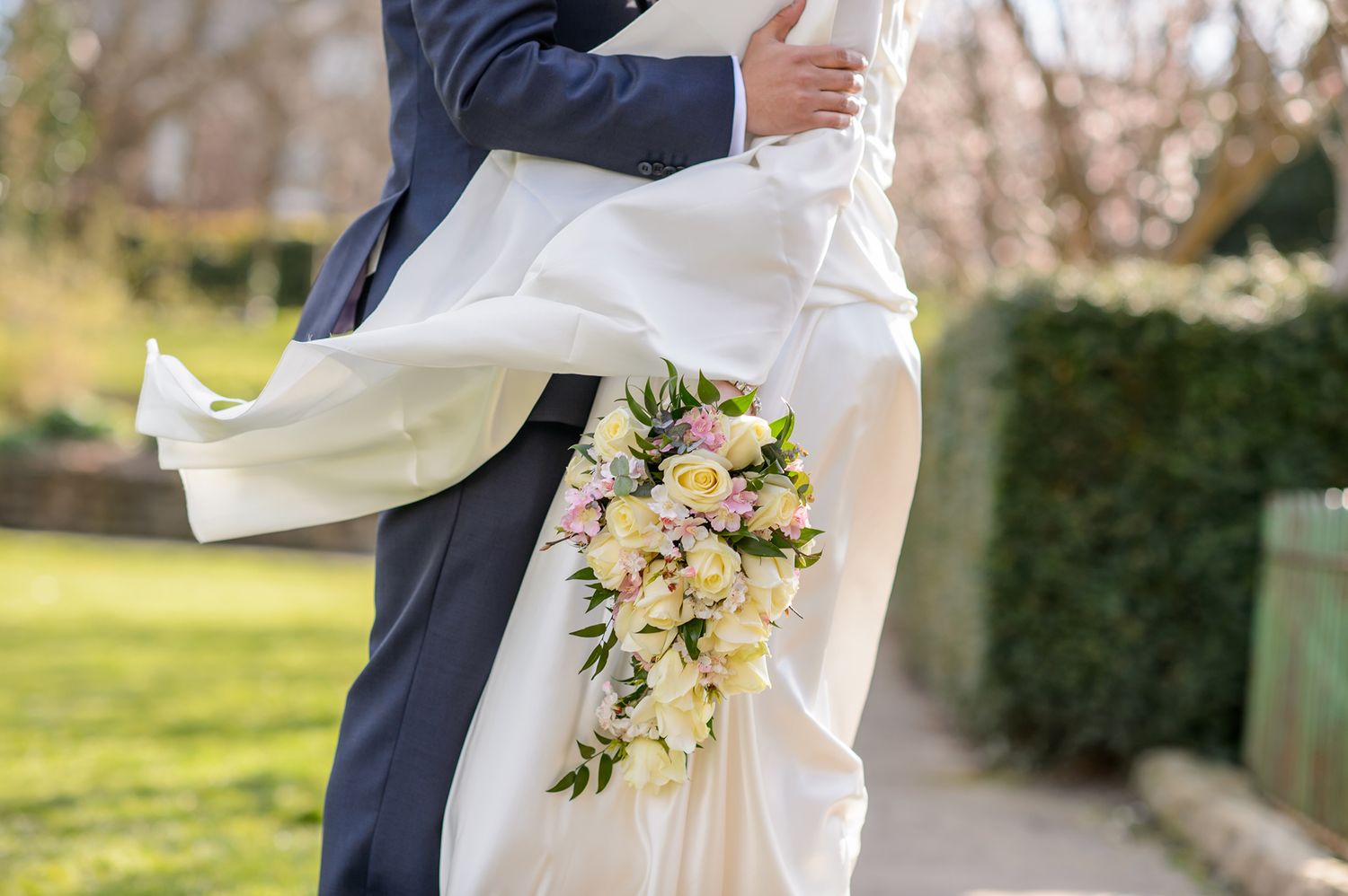 Wedding couple celebrates with guests on a sunny afternoon at an outdoor venue.