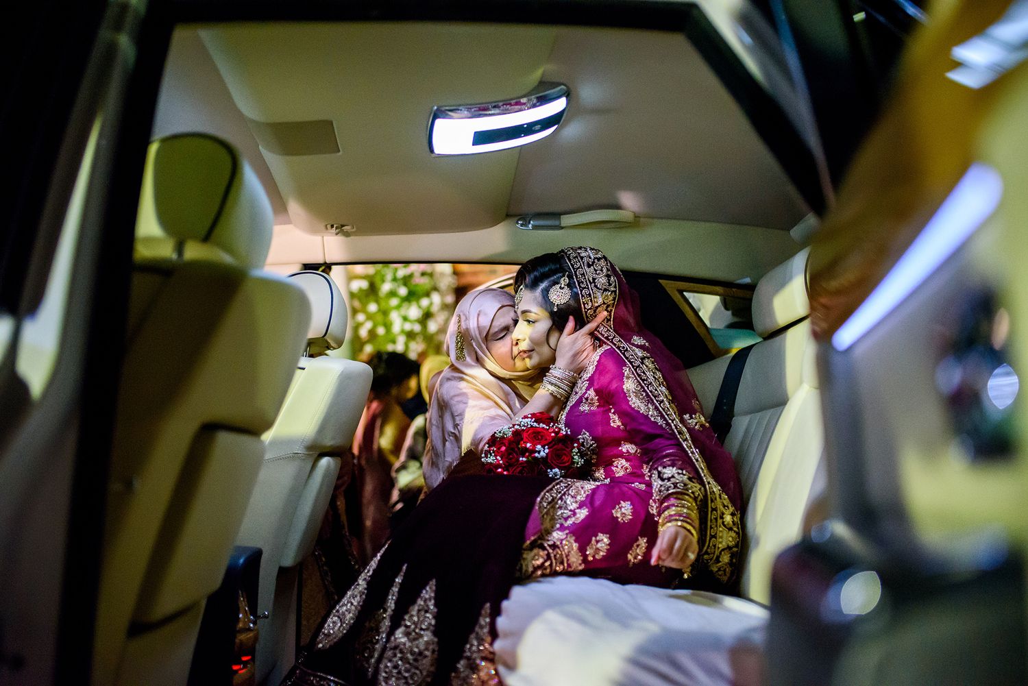 Romantic moment captured inside a luxury car with traditional Indian wedding attire.