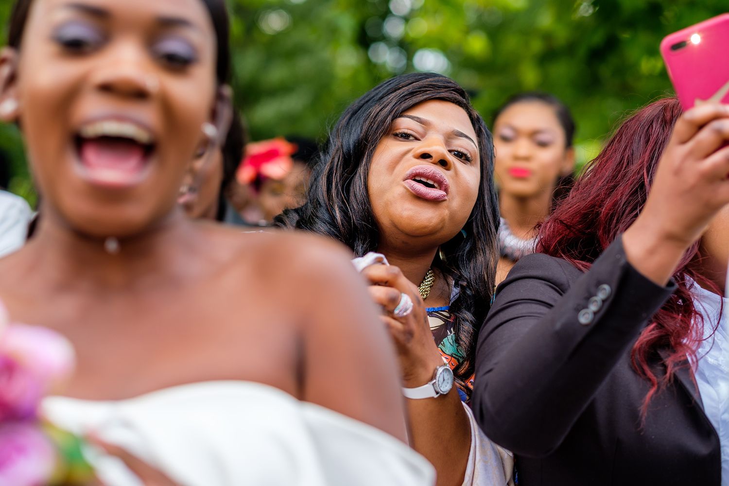 Wedding guests enjoying a joyful celebration outdoors with bright smiles and laughter.