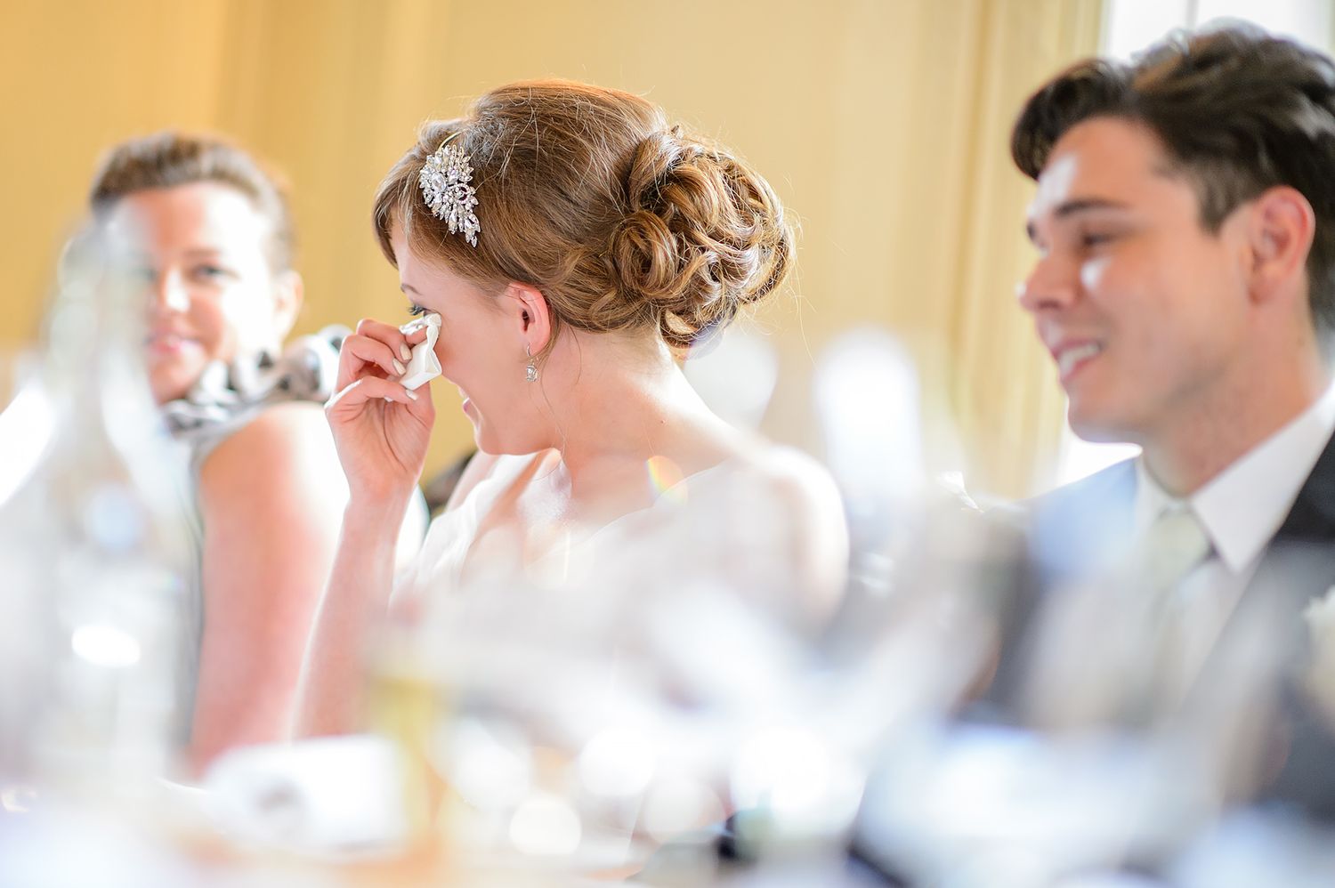 Wedding reception guests seated at elegant tables in a bright, formal dining room.
