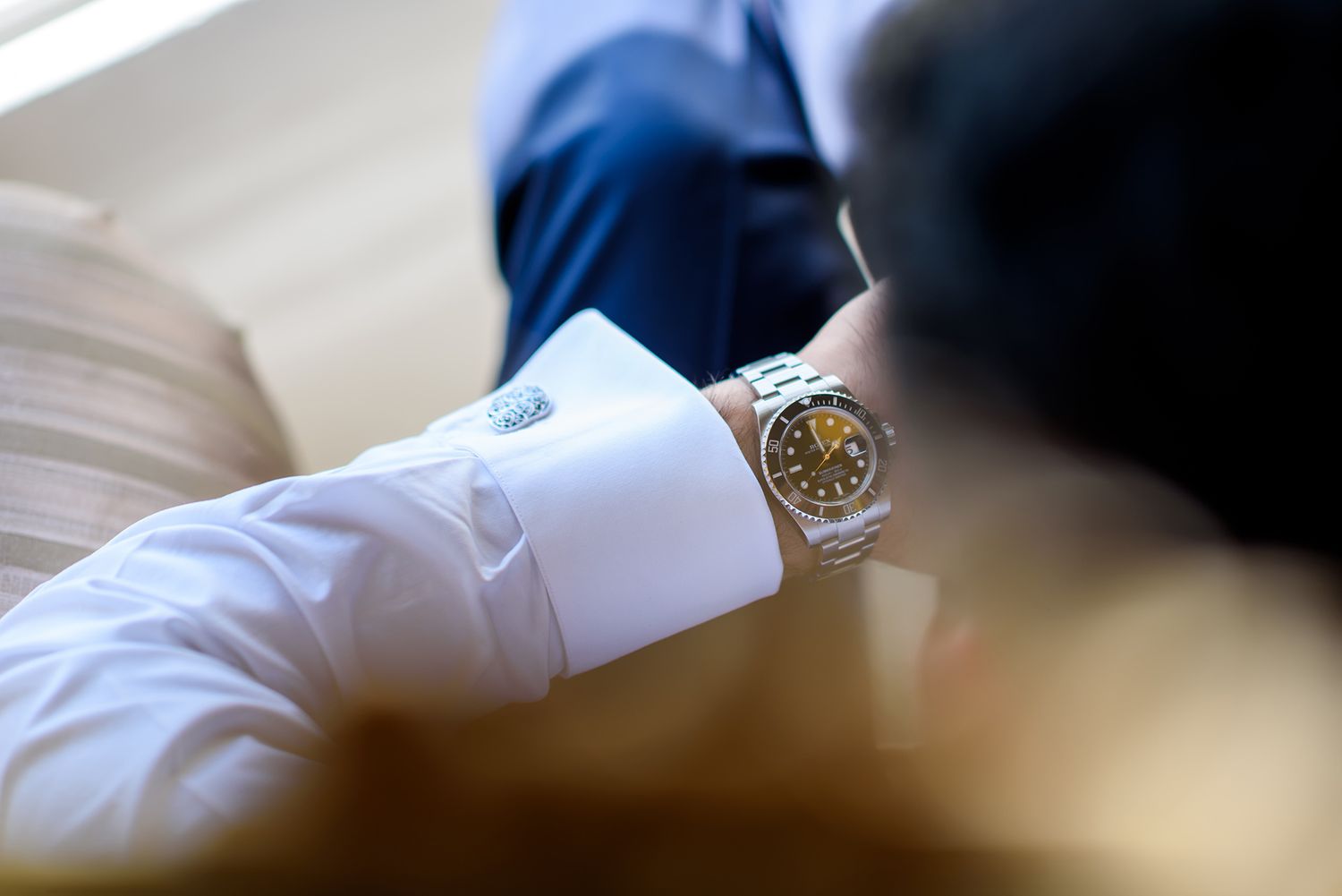Close-up detail shot of luxury watch with white dress shirt cuff.