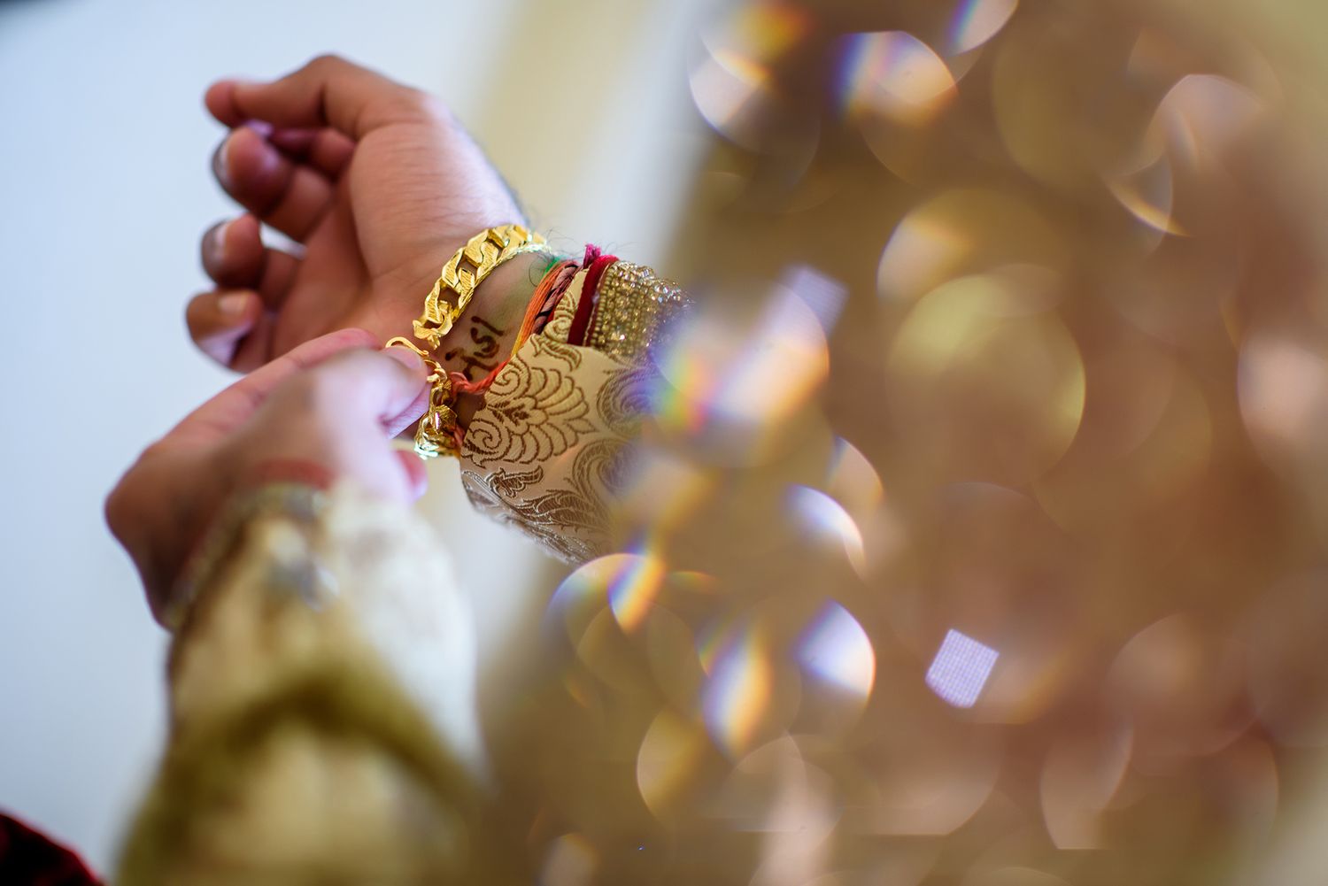 Close-up details of ornate gold jewelry and decorative elements at an Indian wedding ceremony.
