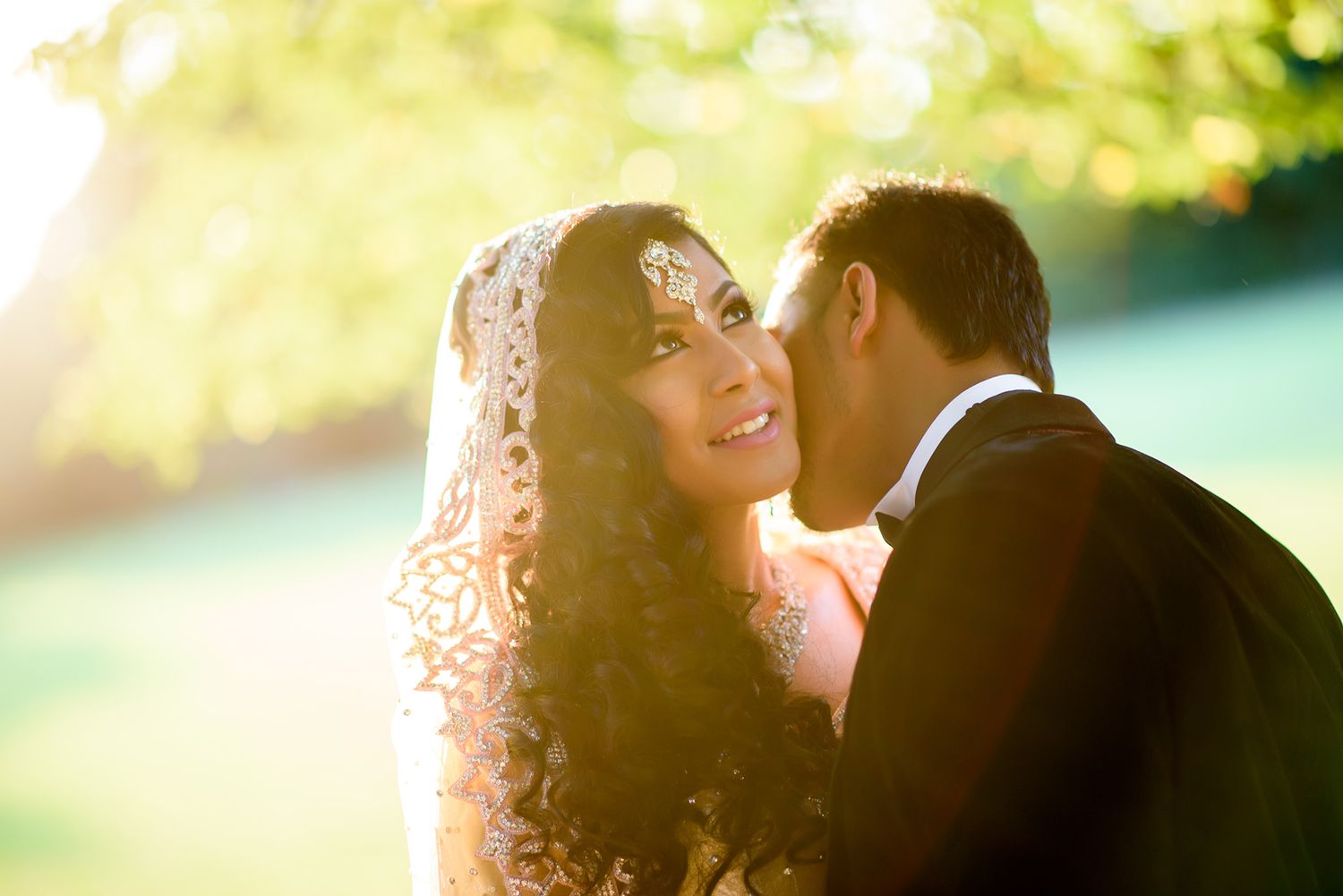 Romantic backlit couple embracing in soft golden afternoon light.