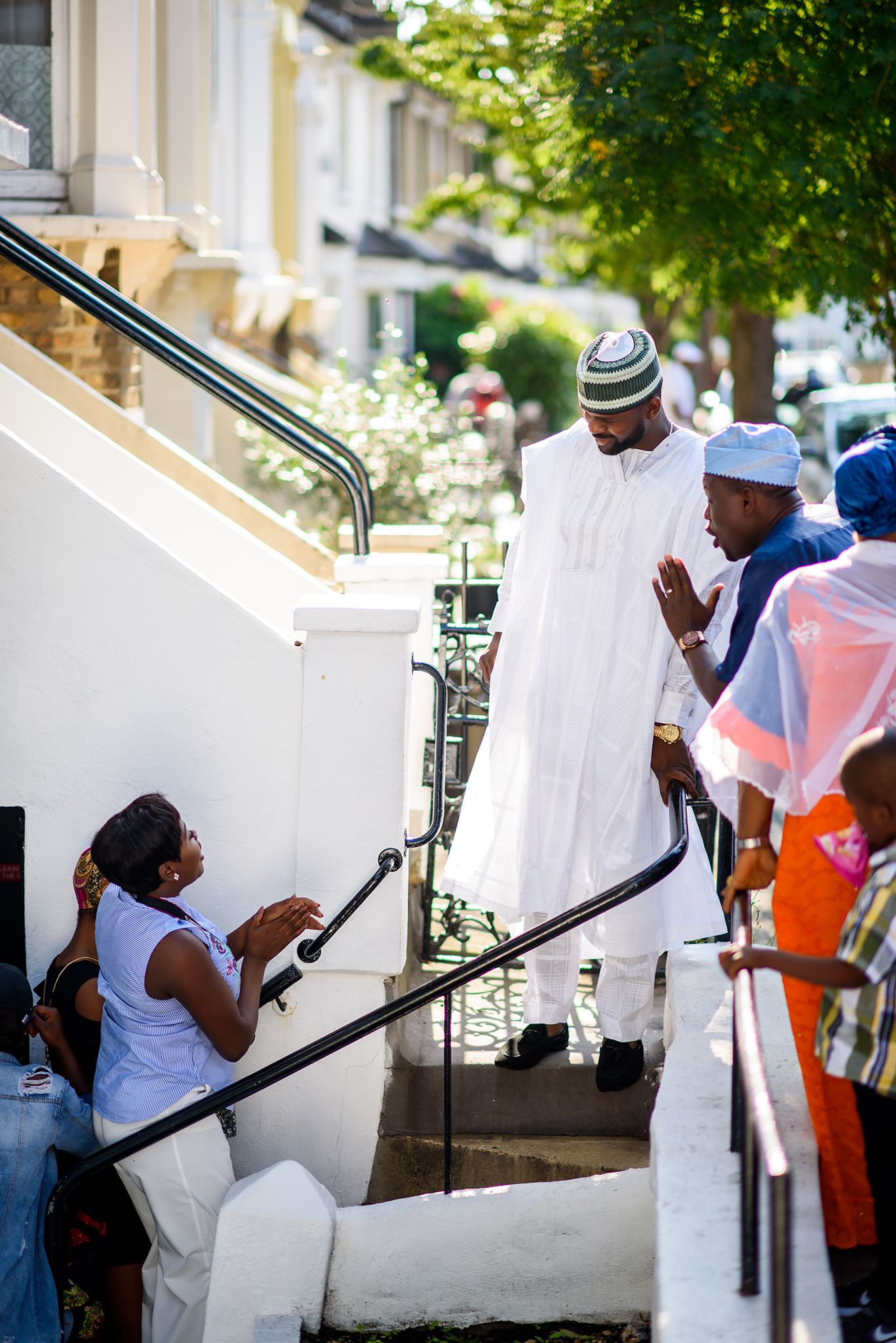Group ascending white stairs outdoors while carrying items.