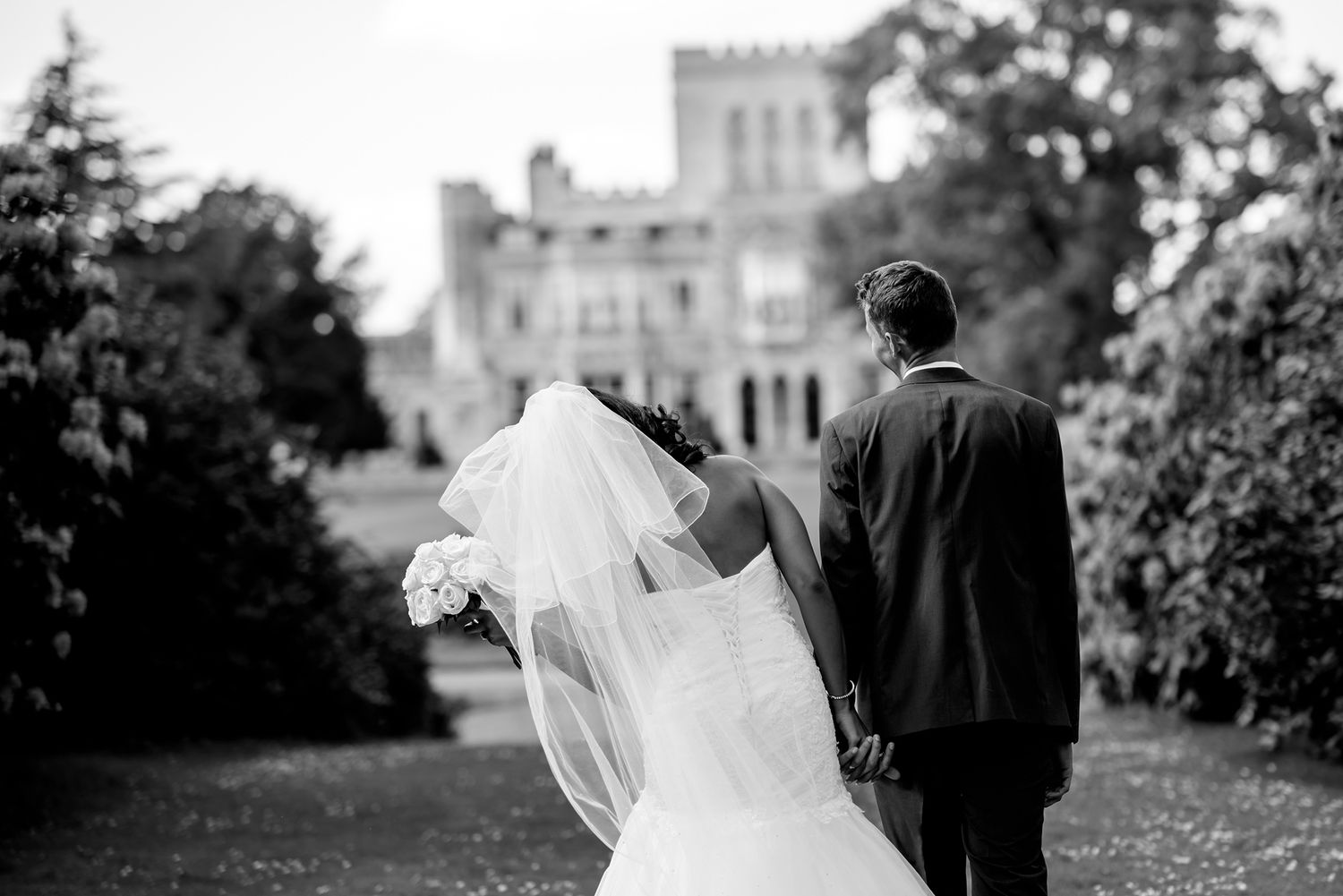 Black and white wedding photography in front of historic stone building.