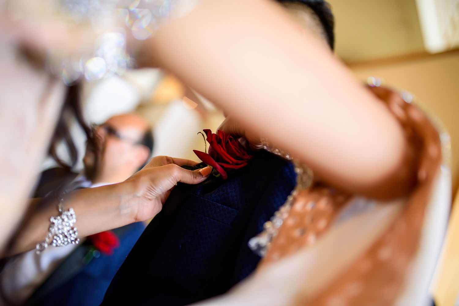 Close-up detail shot of traditional henna designs and jewelry at a wedding ceremony.