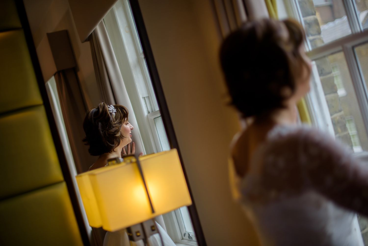 Soft focus wedding preparation scene with natural window lighting.