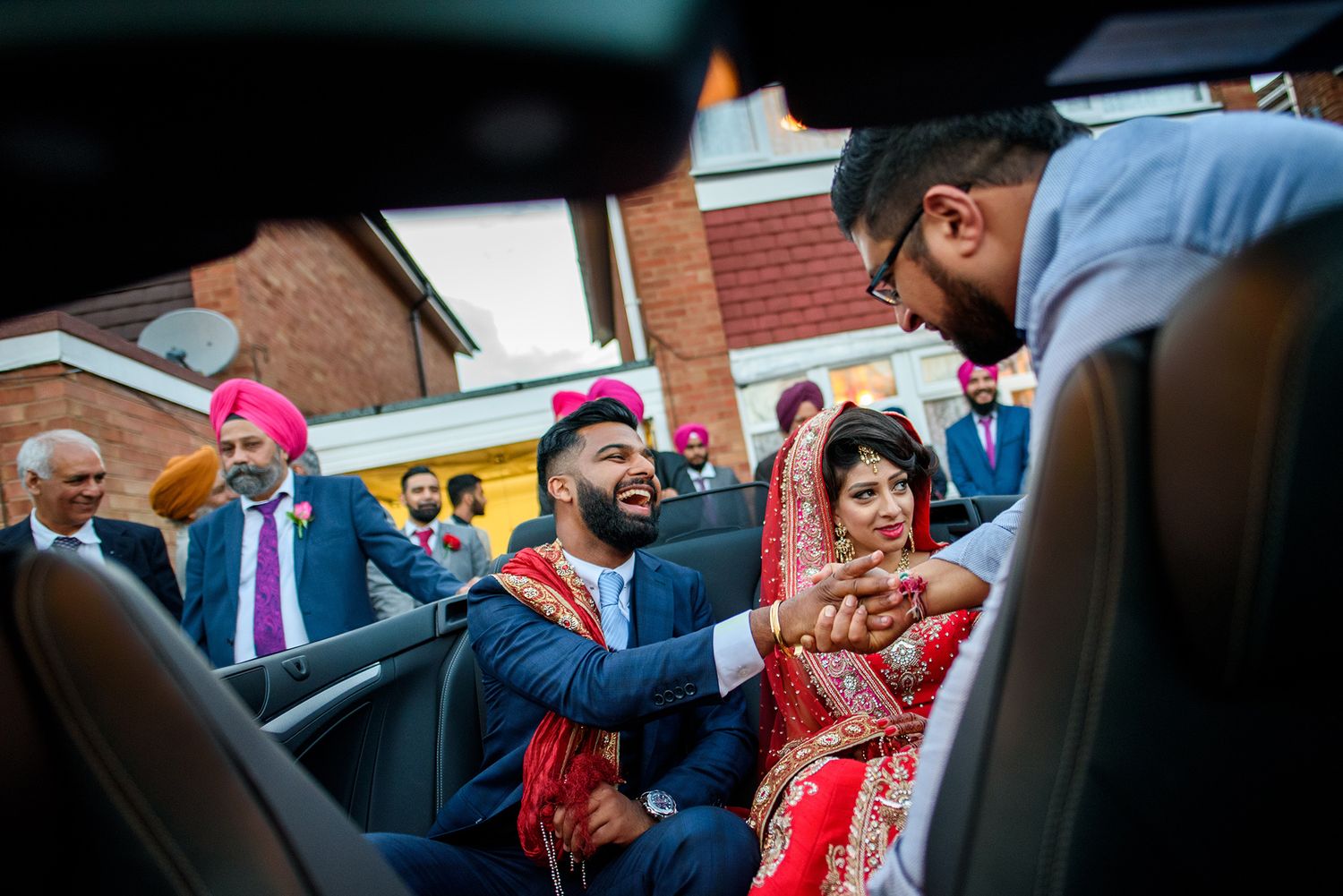 Wedding guests and luxury cars gathered outside during departure ceremony.