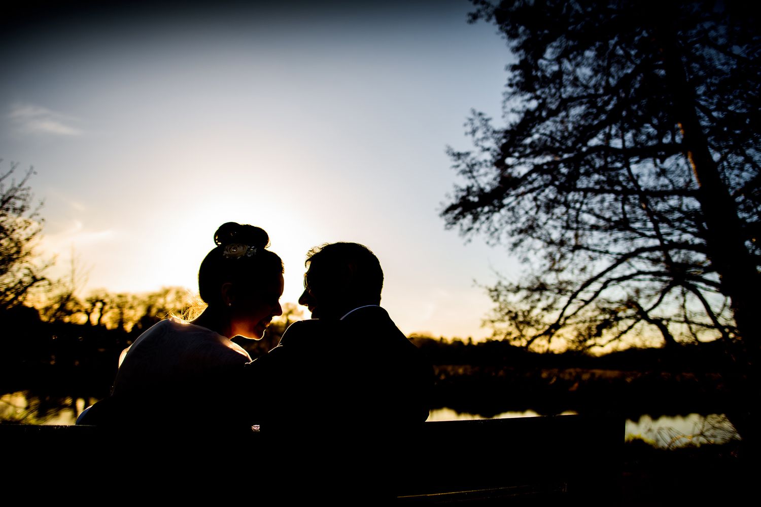Silhouetted wedding couple photos against dramatic sunset sky.