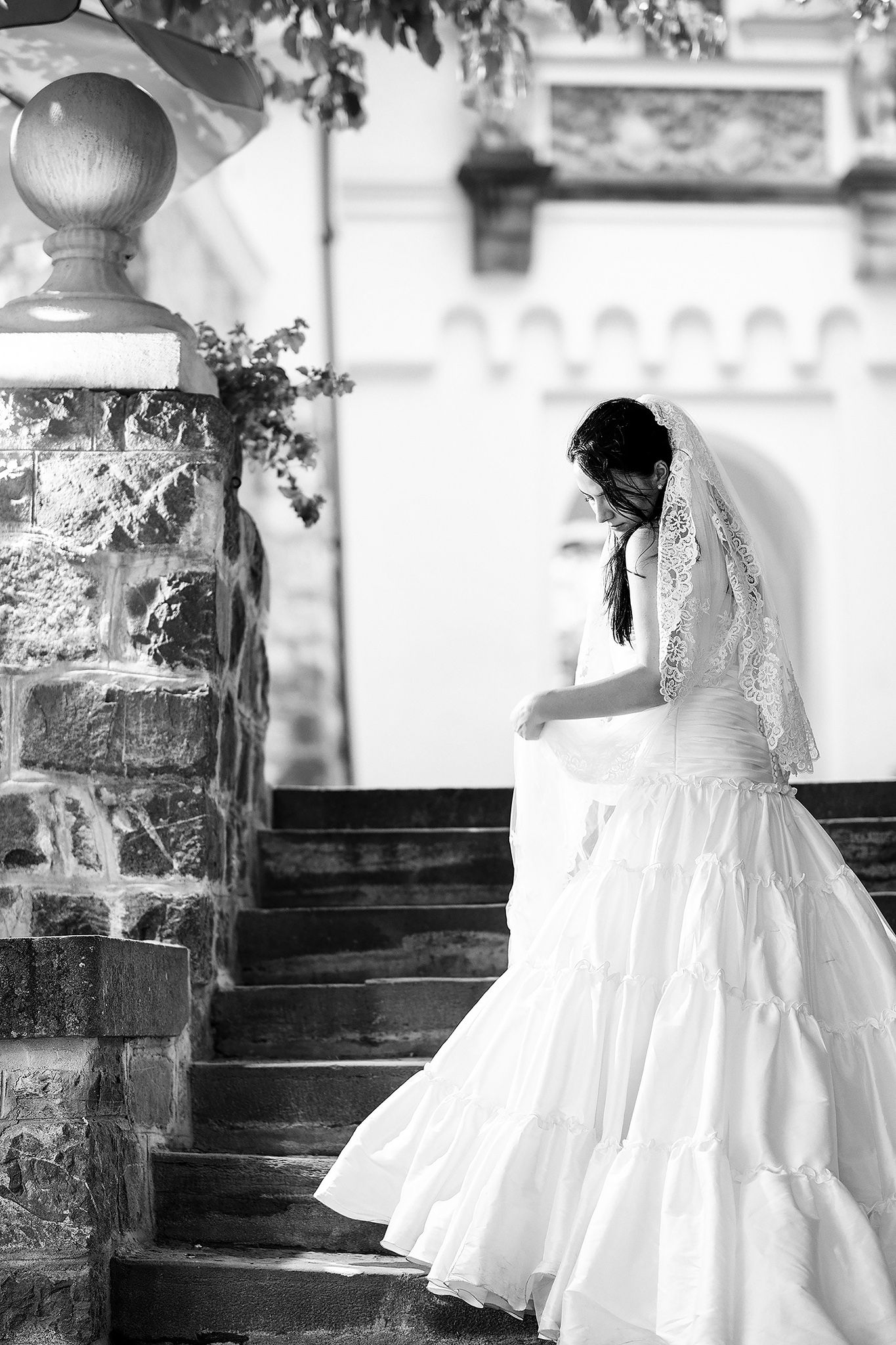Series of artistic black and white photos showing flowing white flower girl dresses on stone steps.