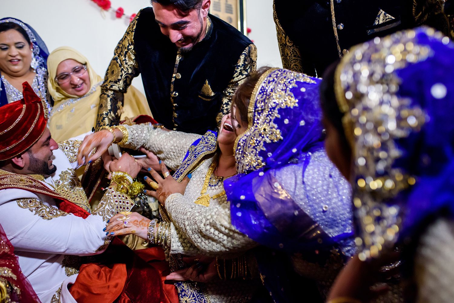 Joyous celebration with guests in colorful traditional attire at cultural wedding reception.