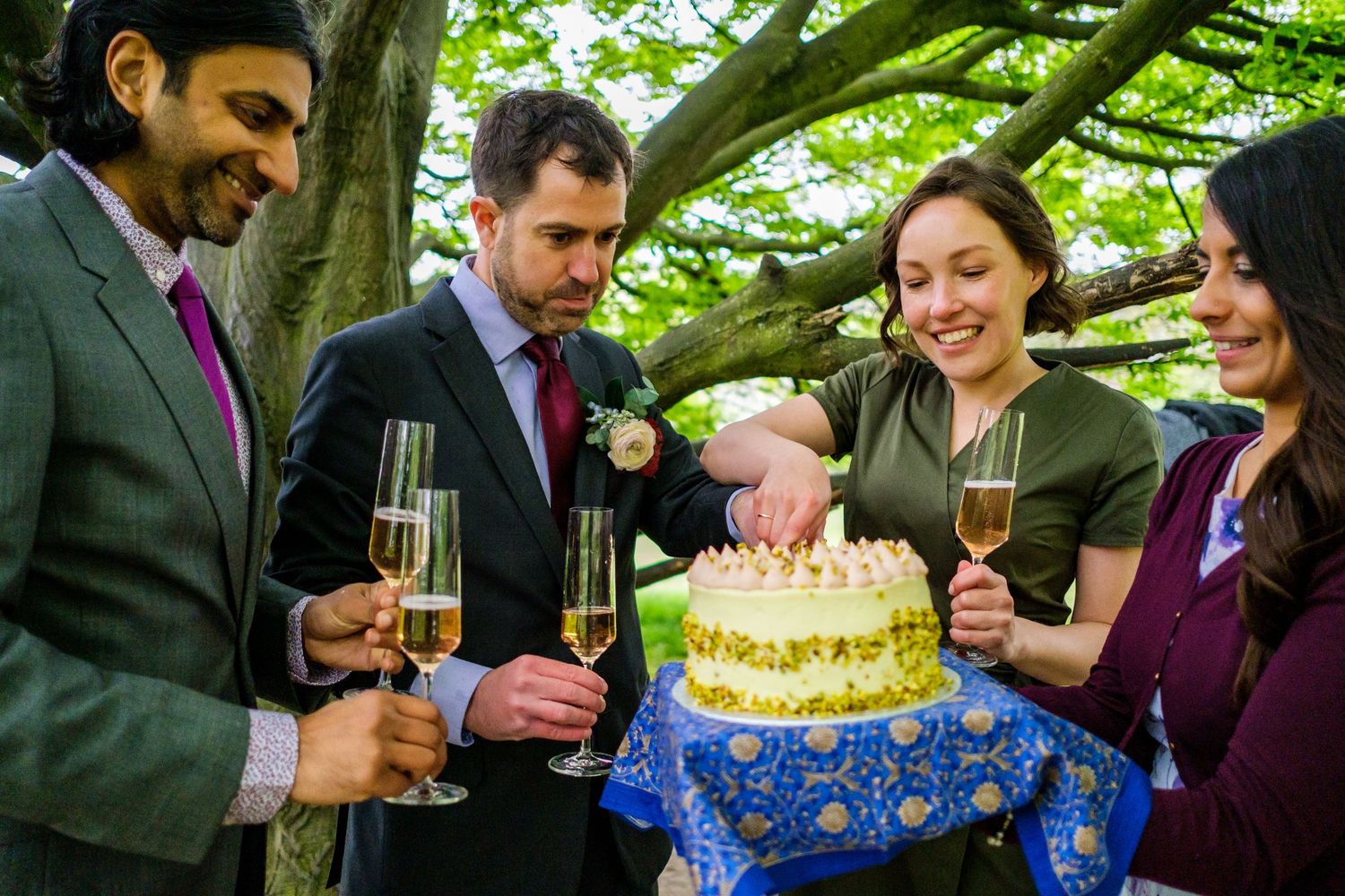 Celebratory moment with birthday cake and champagne in a lush garden setting.